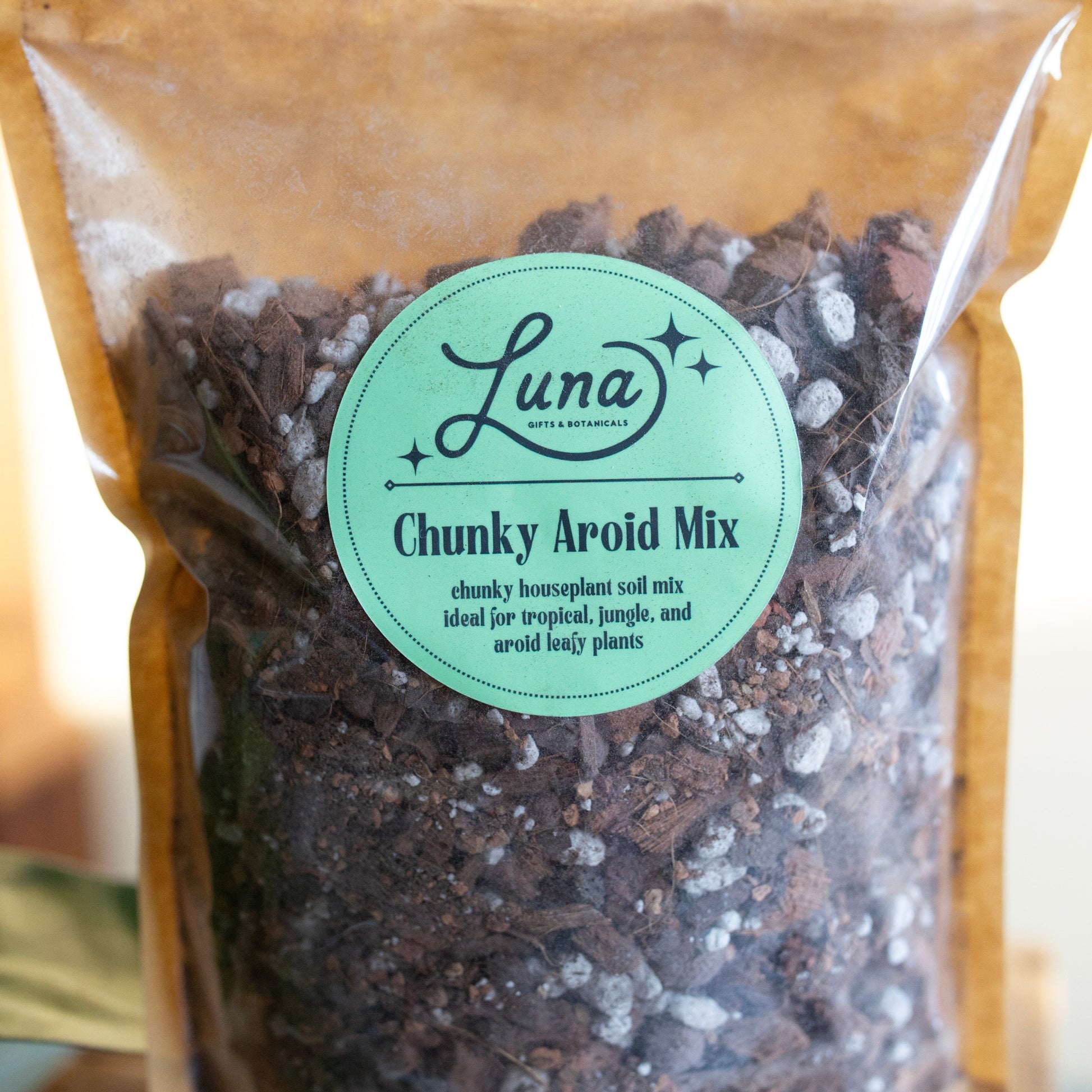 Close up of label of Bag of Luna Chunky Aroid Soil Mixture that reads "Chunky Aroid Mix; chunky houseplant soil mix ideal for tropical, jungle, and aroid leafy plants".